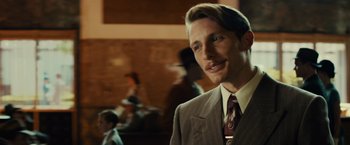 Movie still from “Gangster Squad” (2013), directed by Ruben Fleischer – A man wearing a suit and tie standing in front of a crowd; Close Up shot, Over the shoulder angle