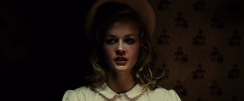 Movie still from “Gangster Squad” (2013), directed by Ruben Fleischer – A woman wearing a hat and a white shirt; Close Up shot, Low angle