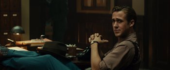 Movie still from “Gangster Squad” (2013), directed by Ruben Fleischer – A man sitting at a table with a cigarette in his hand; Close Up shot, Over the shoulder angle