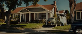 Movie still from “Gangster Squad” (2013), directed by Ruben Fleischer – An old car is parked in front of a house; Extreme Wide shot, Low angle
