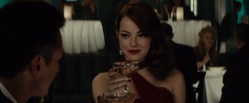 Movie still from “Gangster Squad” (2013), directed by Ruben Fleischer – A beautiful woman holding a wine glass in a red dress; Close Up shot, Over the shoulder angle