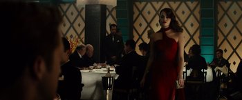 Movie still from “Gangster Squad” (2013), directed by Ruben Fleischer – A woman in a red dress standing in front of a group of people; Medium shot, Over the shoulder angle