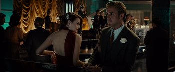 Movie still from “Gangster Squad” (2013), directed by Ruben Fleischer – A man and a woman sitting at a table in front of other people; Medium shot, Over the shoulder angle