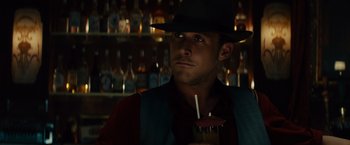 Movie still from “Gangster Squad” (2013), directed by Ruben Fleischer – A man in a hat and a vest holding a drink in a bar; Close Up shot, Over the shoulder angle