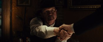 Movie still from “Gangster Squad” (2013), directed by Ruben Fleischer – A man in a fedora shaking hands with another man in a suit; Close Up shot, Over the shoulder angle
