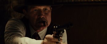 Movie still from “Gangster Squad” (2013), directed by Ruben Fleischer – A man in a hat is holding a gun; Close Up shot, Low angle