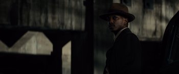 Movie still from “Gangster Squad” (2013), directed by Ruben Fleischer – A man wearing a suit and a brown hat; Close Up shot, Over the shoulder angle