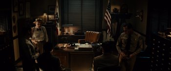 Movie still from “Gangster Squad” (2013), directed by Ruben Fleischer – A group of people sitting at a desk in front of a window; Wide shot, High angle