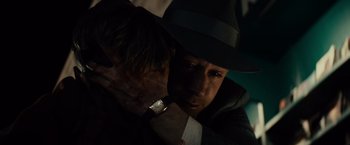 Movie still from “Gangster Squad” (2013), directed by Ruben Fleischer – A man in a hat and a watch is hugging another man in a suit; Close Up shot, Over the shoulder angle