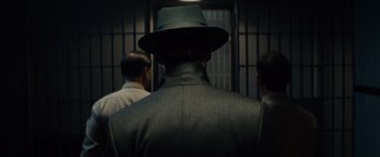 Movie still from “Gangster Squad” (2013), directed by Ruben Fleischer – A man wearing a hat standing in front of two other men; Close Up shot, Low angle