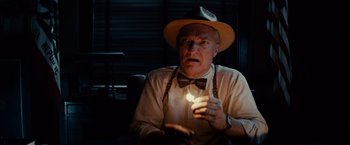 Movie still from “Gangster Squad” (2013), directed by Ruben Fleischer – An older man wearing a hat and a bow tie holding a lit candle; Close Up shot, Low angle