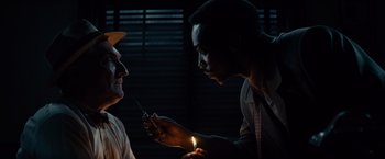 Movie still from “Gangster Squad” (2013), directed by Ruben Fleischer – A man holding a cell phone up to another man's ear; Close Up shot, Low angle