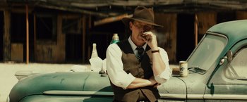 Movie still from “Gangster Squad” (2013), directed by Ruben Fleischer – A man in a hat and vest smoking a cigarette; Medium shot, Low angle