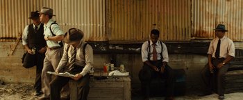 Movie still from “Gangster Squad” (2013), directed by Ruben Fleischer – Two men sitting next to each other on a bench; Wide shot, High angle