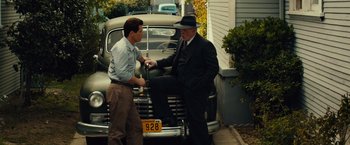 Movie still from “Gangster Squad” (2013), directed by Ruben Fleischer – Two men standing next to each other in front of an old car; Medium shot, Low angle