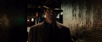 Movie still from “Gangster Squad” (2013), directed by Ruben Fleischer – A man wearing a suit and a hat in the dark; Close Up shot, Low angle