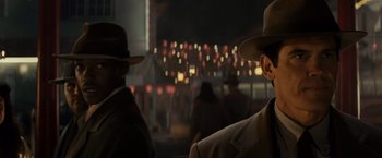 Movie still from “Gangster Squad” (2013), directed by Ruben Fleischer – Two men in suits and hats are standing in front of lights; Close Up shot, Over the shoulder angle