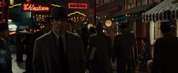 Movie still from “Gangster Squad” (2013), directed by Ruben Fleischer – A group of people walking down a street at night; Medium shot, Over the shoulder angle