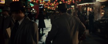 Movie still from “Gangster Squad” (2013), directed by Ruben Fleischer – A group of people walking down a street at night; Medium shot, Over the shoulder angle