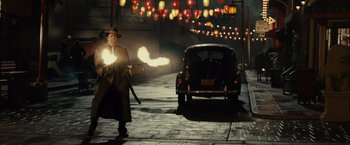 Movie still from “Gangster Squad” (2013), directed by Ruben Fleischer – A man in a hat and a coat is holding a gun; Wide shot, High angle