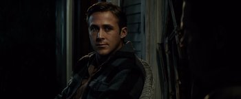 Movie still from “Gangster Squad” (2013), directed by Ruben Fleischer – A person sitting in a chair wearing a jacket; Close Up shot, Over the shoulder angle