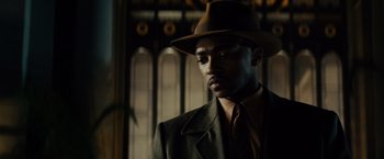 Movie still from “Gangster Squad” (2013), directed by Ruben Fleischer – A man wearing a suit and a hat in front of a window; Close Up shot, Low angle