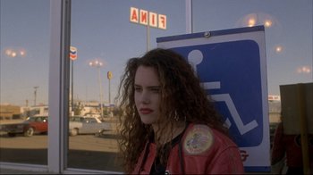 Movie still from “Gas Food Lodging” (1992), directed by Allison Anders – A woman with curly hair and a red leather jacket; Medium shot, Over the shoulder angle