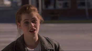 Movie still from “Gas Food Lodging” (1992), directed by Allison Anders – A young woman is sitting on the sidewalk; Close Up shot, Over the shoulder angle