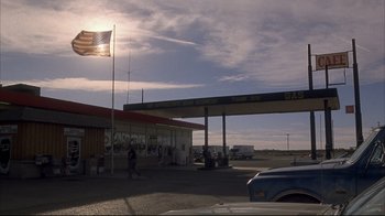 Movie still from “Gas Food Lodging” (1992), directed by Allison Anders – A gas station with people waiting at the gas pumps; Extreme Wide shot, Low angle