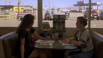 Movie still from “Gas Food Lodging” (1992), directed by Allison Anders – Two people sitting at a table in a restaurant; Medium shot, Over the shoulder angle