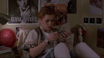 Movie still from “Gas Food Lodging” (1992), directed by Allison Anders – A young woman sitting on a couch looking at her cell phone; Medium shot, High angle