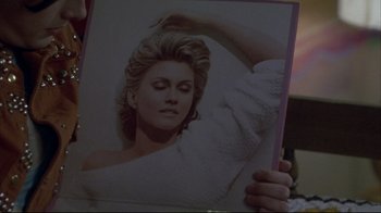 Movie still from “Gas Food Lodging” (1992), directed by Allison Anders – A person holding up a picture of a woman; Close Up shot, Overhead angle