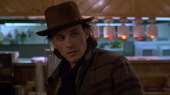 Movie still from “Gas Food Lodging” (1992), directed by Allison Anders – A man wearing a brown hat and a brown jacket; Close Up shot, Over the shoulder angle
