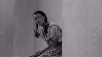 Movie still from “Gas Food Lodging” (1992), directed by Allison Anders – A woman with braids leaning up against a wall; Medium shot, Low angle