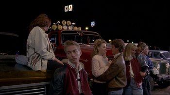 Movie still from “Gas Food Lodging” (1992), directed by Allison Anders – A group of people standing next to each other near a red truck; Medium shot, Over the shoulder angle