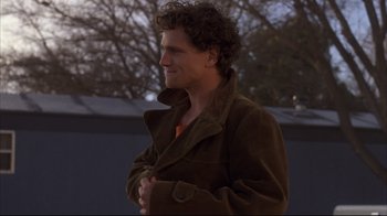 Movie still from “Gas Food Lodging” (1992), directed by Allison Anders – A man with curly hair wearing a brown jacket; Medium shot, Over the shoulder angle
