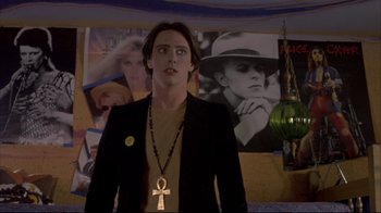 Movie still from “Gas Food Lodging” (1992), directed by Allison Anders – A man standing in front of a picture of a woman; Medium shot, Over the shoulder angle