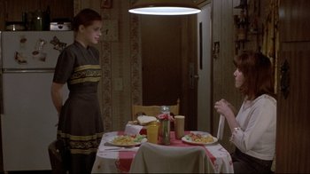 Movie still from “Gas Food Lodging” (1992), directed by Allison Anders – Two people sitting at a table with plates of food on top of it; Medium shot, High angle