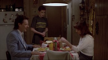 Movie still from “Gas Food Lodging” (1992), directed by Allison Anders – A man and a woman sitting at a dinner table with a young boy; Medium shot, High angle