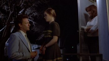 Movie still from “Gas Food Lodging” (1992), directed by Allison Anders – A man and a woman standing next to each other on a street; Medium shot, Over the shoulder angle