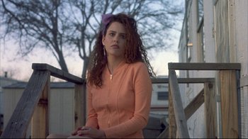 Movie still from “Gas Food Lodging” (1992), directed by Allison Anders – A young woman with long curly red hair wearing an orange jacket; Medium shot, Low angle