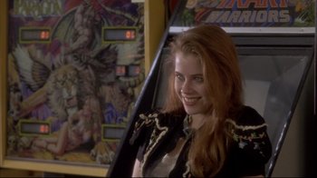 Movie still from “Gas Food Lodging” (1992), directed by Allison Anders – A beautiful young woman standing in front of an arcade machine; Close Up shot, Over the shoulder angle