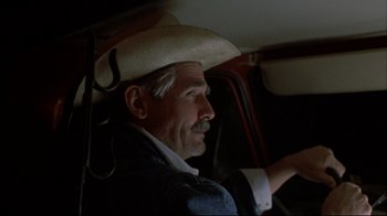 Movie still from “Gas Food Lodging” (1992), directed by Allison Anders – An older man wearing a cowboy hat sitting in the driver's seat of a car; Close Up shot, Low angle