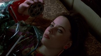 Movie still from “Gas Food Lodging” (1992), directed by Allison Anders – A woman is holding a film reel in her hand; Close Up shot, Overhead angle