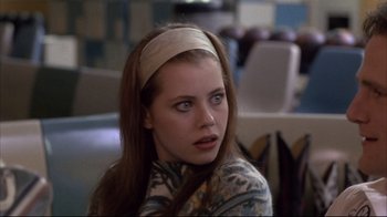 Movie still from “Gas Food Lodging” (1992), directed by Allison Anders – A woman with long brown hair wearing a headband; Close Up shot, Low angle
