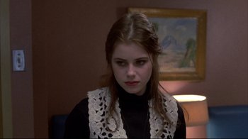 Movie still from “Gas Food Lodging” (1992), directed by Allison Anders – A woman in a black shirt and a lace vest; Close Up shot, Over the shoulder angle