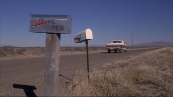 Movie still from “Gas Food Lodging” (1992), directed by Allison Anders – A car parked on the side of the road next to a mailbox; Wide shot, Low angle