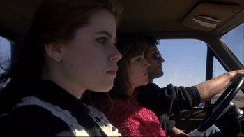 Movie still from “Gas Food Lodging” (1992), directed by Allison Anders – A couple of people sitting in a car looking out the window; Close Up shot, Low angle