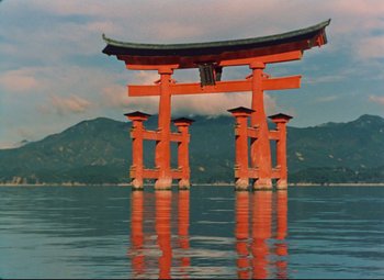 An orange gate in the middle of a body of water