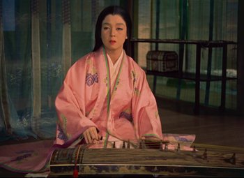 A woman in a pink kimono playing a musical instrument